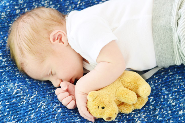 Newborn Photo Of Infant Son On Homemade Knitted Blanket and Small Bear