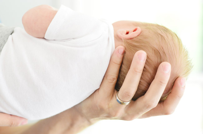 Dad Hand Holding Newborn Head For Birth Announcement Photoshoot