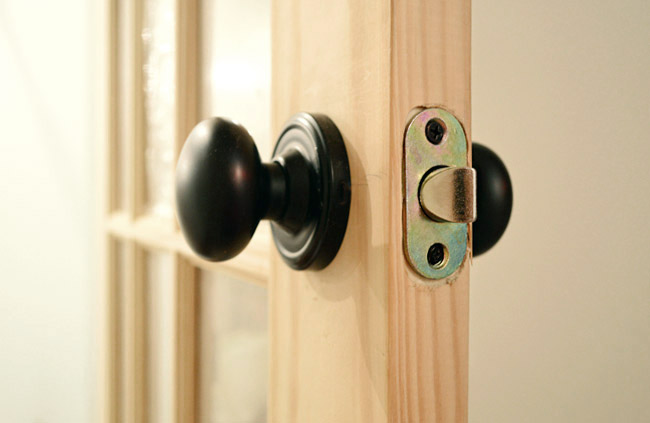 Oil Rubbed Bronze Door Knob Set Into Newly Created Holes In Unfinished Door
