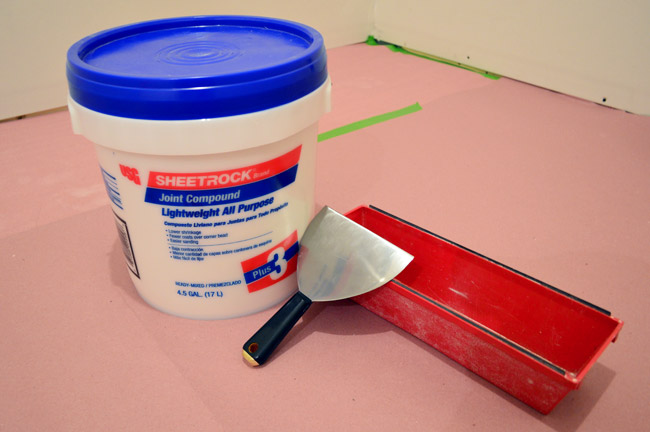drywall mud or sheetrock join compound with spackle knife and mud pan