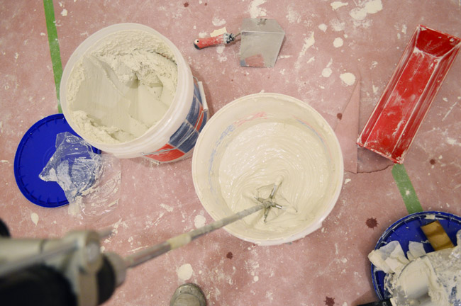 mixing bucket of drywall mud joint compound with drill mixing paddle