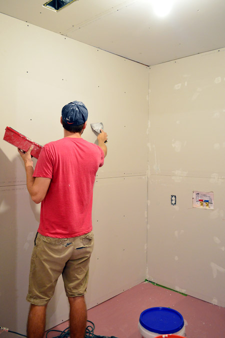 John applying mud over drywall screw head marks