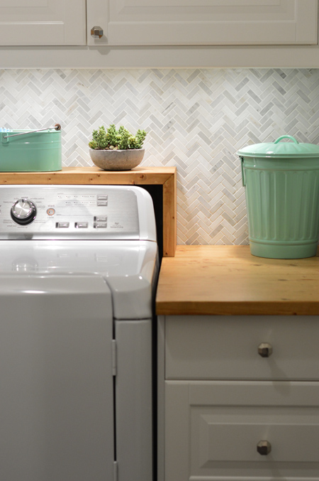 Detail of Marble Herringbone Backsplash With Under Cabinet Lights In Laundry Room